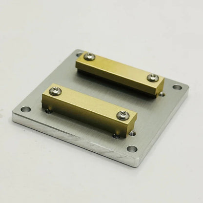 Aluminium plate 60 by 60 mm with two brass rails bolted across the top