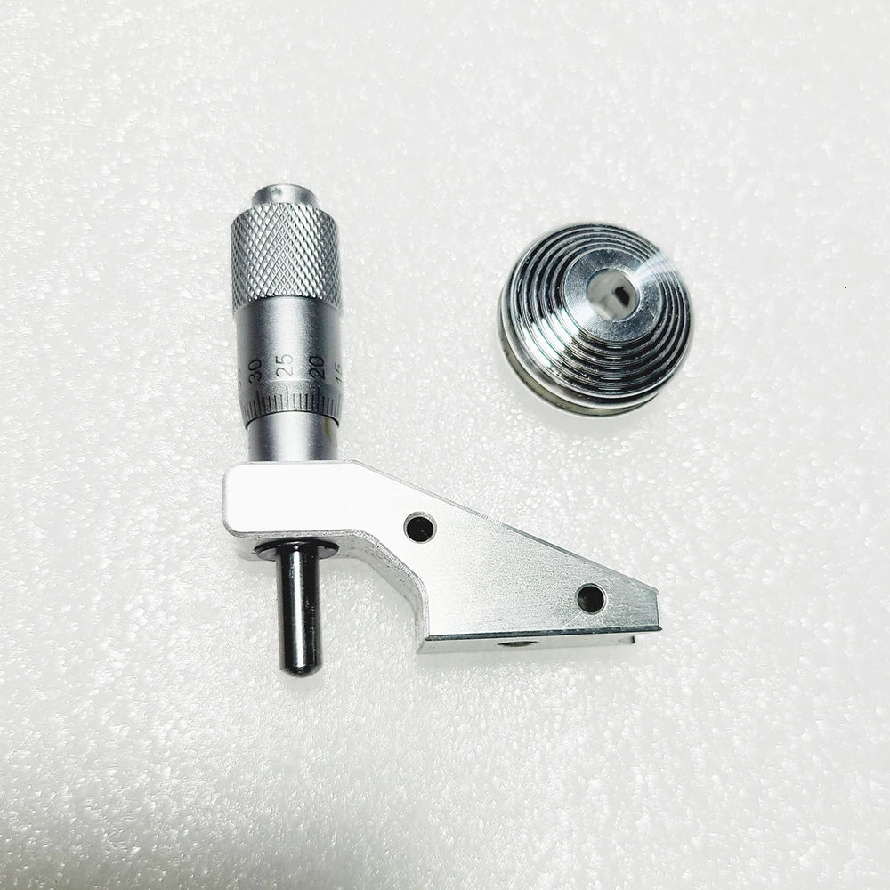 The micrometer head beside the seven groove cone pulley
